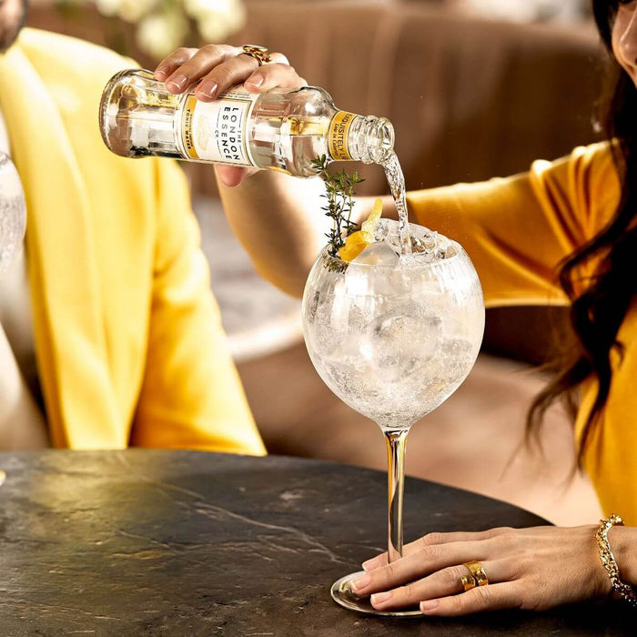 Wholesale London Essence - Original Indian Tonic Water 200ml being poured into a gin glass with ice